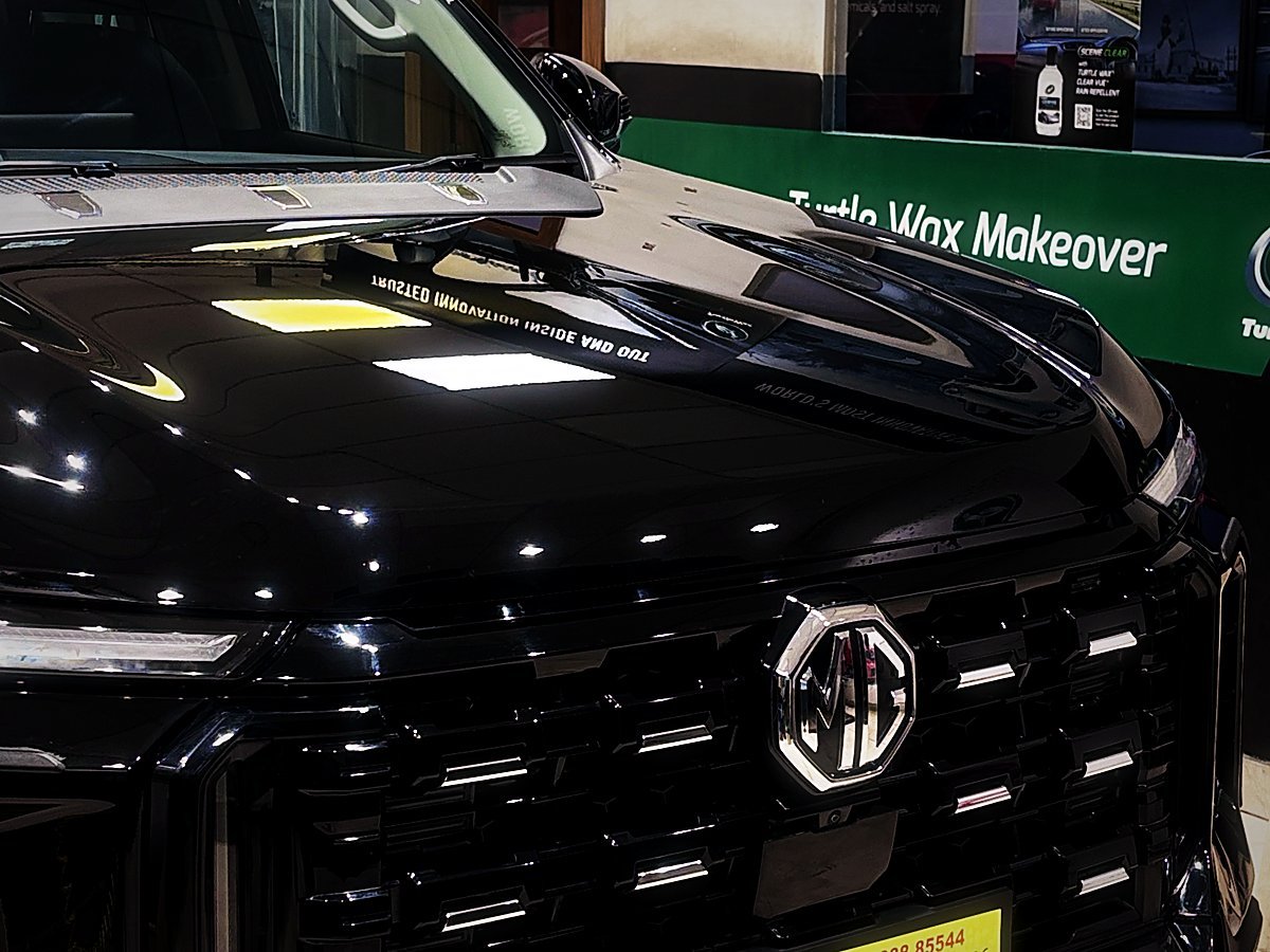 A black MG SUV under the Turtle Wax Makeover board inside the Tellapur studio