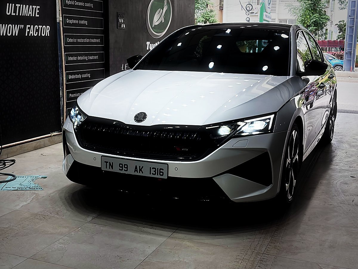 A white sedan with its LED headlights on inside the Turtle Wax Studio Tellapur bay