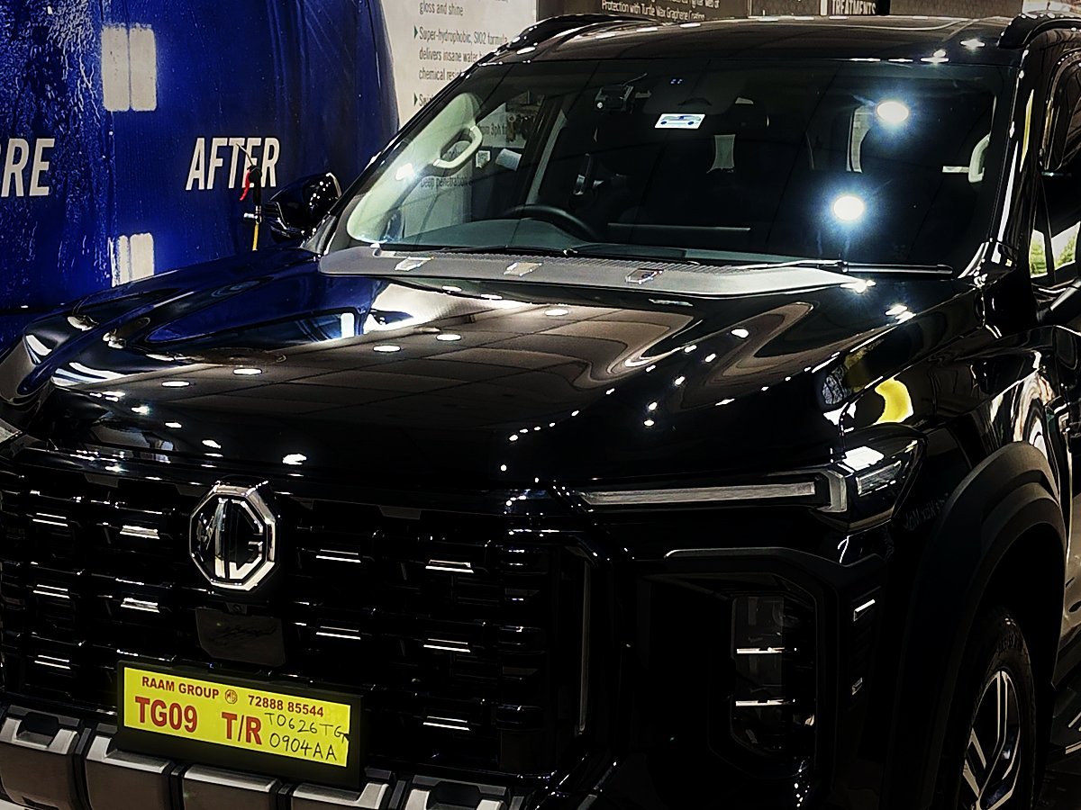 A glossy black MG Gloster at the before-and-after board inside Turtle Wax Studio Tellapur